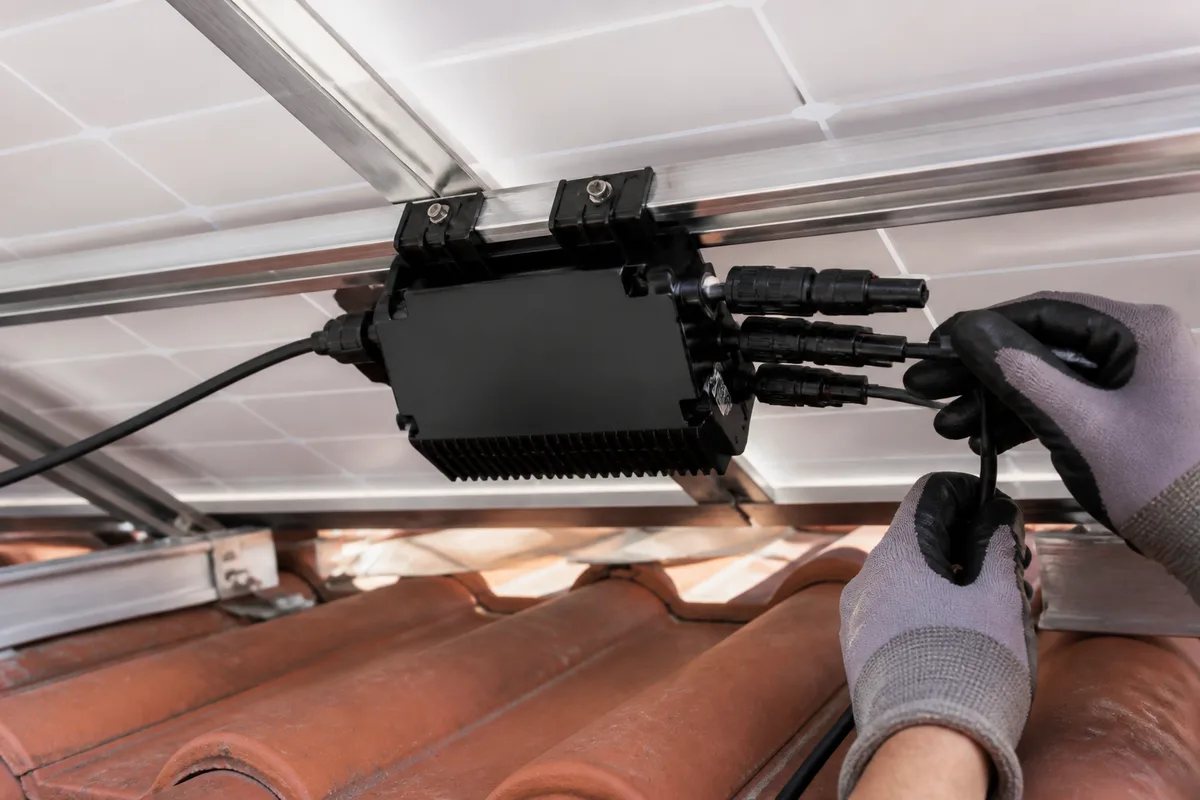 Micro-onduleur fixé sur le rail de montage sous un panneau solaire en toiture